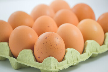 Closeup of a cardboard tray with brown eggs