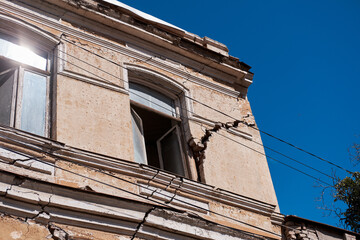 Destroyed building by war the backdrop of a clear blue sky. Bottom view.