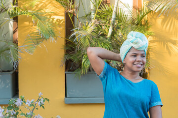A portrait of a beautiful afro woman with a green headscarf as a turban.