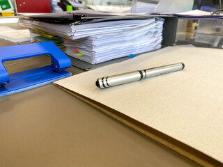 Large thick folders with important papers and documents on a working office desk with stationery and accessories
