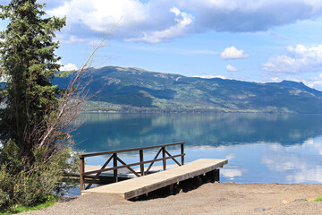 View of a lake with a dock and mountains in the background