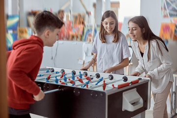Elementary school kids in a classroom playing table football. Fun while recess at school
