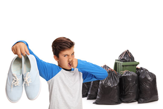 Chilf throwing a pair of smelly shoes in a waste bin