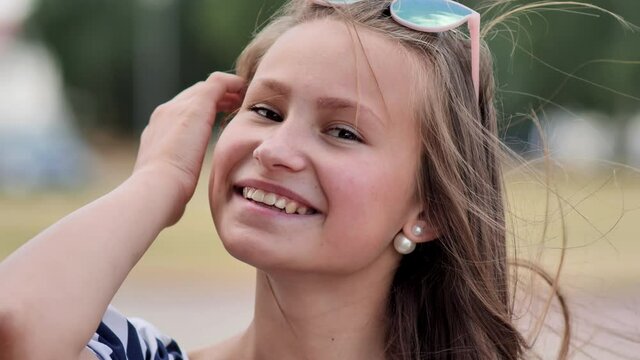 Portrait of a young smiling girl in the park on a summer day.