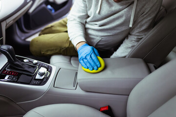 A man cleaning car interior, car detailing (or valeting) concept. Selective focus.