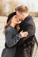 Man hugs and kisses his wife. Couple on the shore of a lake in Germany. Lovers hug each other. Young couple outside 