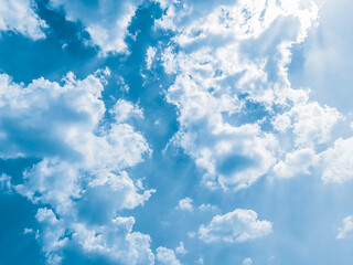 background of Summer sky of fluffy clouds, sun shining and moving clouds with copy space.