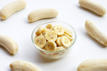 Banana slices in glass bowl on white