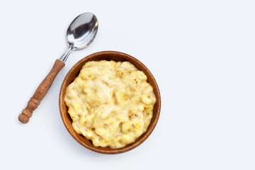Mashed Bananas in wooden bowl on white background.