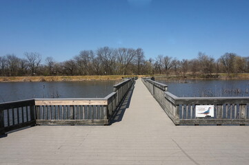 Boardwalk Bridge Crossing Wetland Lake on Early Spring Day