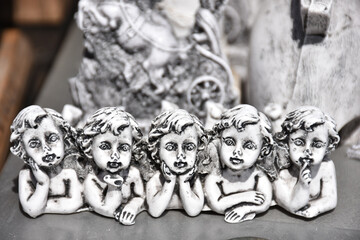 Various small statues with angel faces on the counter at the public market in Pergamon, Bergama