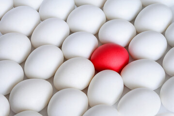 White boiled eggs and one red egg on white background