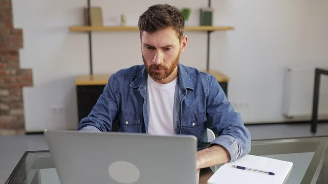 Shocked frustrated businessman, student feeling stressed, looking at computer screen, worried about a problem, reading bad online news, getting failed exam results