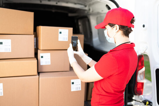 Caucasian courier checking the shipping labels with a smartphone