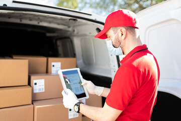 Rear view of a delivery man scanning the barcode of a package