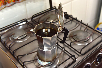 Italian coffee maker passing coffee on the stove.
