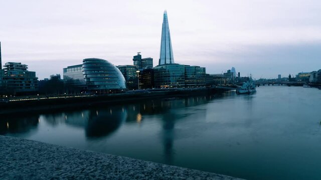 Time lapse of City Hall, London UK, as night settles in and boats sail on the river Thames.