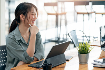 Young beautiful asian woman in casual wear laughing and relaxing during work at office.