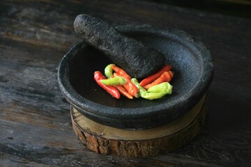 Mortar contains colorful chilies, ready to be pulverized and processed into chili sauce and other...