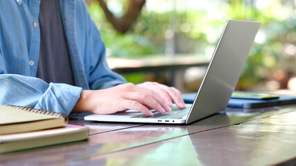 Close up of man hand tying laptop computer while sitting in campus, online class, e learning
