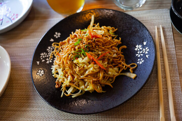Japanise style noodles with vegetables yakisoba beautifully served in the bowl. High quality photo