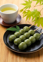 mugwort-flavored rice dumpling and green tea on a wooden table