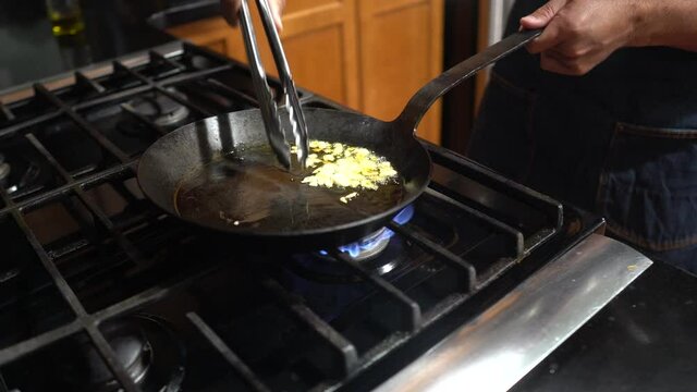 Deep fry garlic with oil in black fry pan