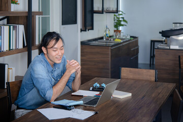 Fototapeta na wymiar asian guy focus on his a work on desk with good attitude