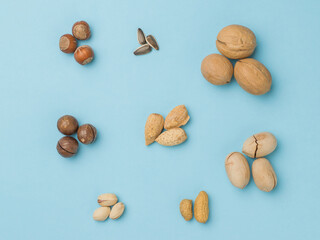 Several sets of different nuts on a blue background. Flat lay.