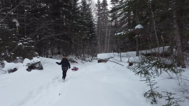 petit gar&ccedil;on courant dans un chemin de neige en for&ecirc;t
