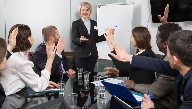 Successful elderly business woman presenting new business strategy to partners in boardroom