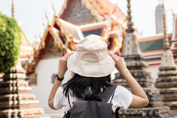 Fototapeta na wymiar Traveler, travel young asian woman or girl wear hat, look at pagoda temple, city tourism, happy on sunny day. Backpacker tourist, holiday trip,s ummer or vacation, hobby on sunny day concept.