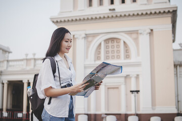 Traveler, travel young asian woman or girl using local map to sightseeing, city tourism on happy sunny day. Backpacker tourist, holiday trip,summer holiday or vacation, hobby concept.