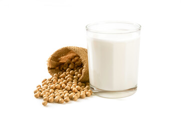 Glass of soymilk with soybeans in bag on white background.
