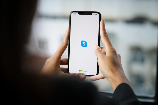 CHIANG MAI, THAILAND - April 06 ,2021: Woman holding iphone with skype apps. Skype is part of Microsoft, can make video, audio calls, chat messages and do much more using Skype