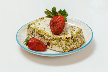 Halva with pistachios on plate on white background