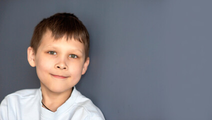 portrait of a boy 8-10 on a blue isolated background, space for text, selective focus
