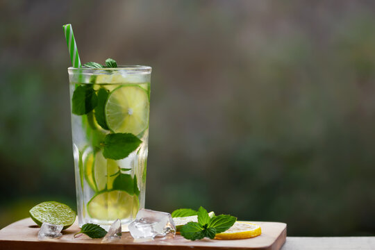 Cold refreshing homemade lemonade with mint, lemon and lime in a glass, copyspace