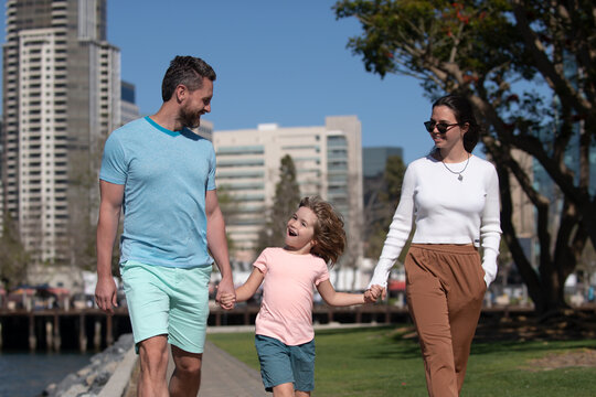 Happy Family With Little Child Son Walking In City. Young Couple Walk In City Park With Son.