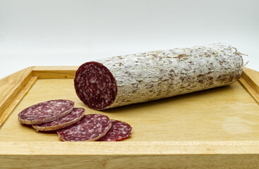 Salami sliced on cutting board, white background