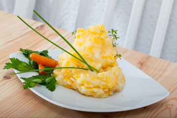 Homemade mashed potatoes garnished with glazed carrots, parsley and chives