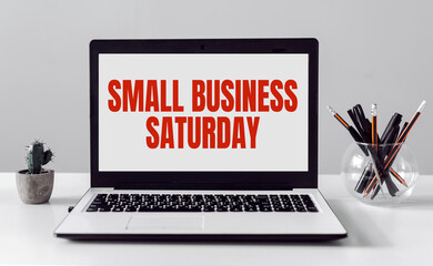 Laptop with Small Business Saturday text on modern office background.