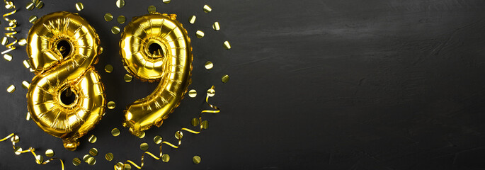 golden foil balloon number eighty nine. Birthday or anniversary card with the inscription 89. Black concrete background. Anniversary celebration. Banner.