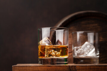Scotch whiskey glass and old barrel