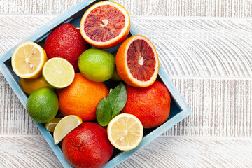 Various fresh citrus fruits in wooden box