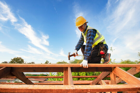An old man carpenter works the roof truss on the roof truss construction site.