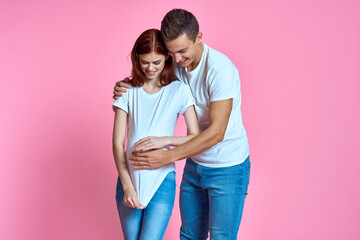 young couple family parents pink background hug