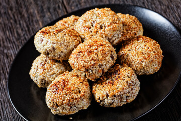 sesame lamb patties on a black plate
