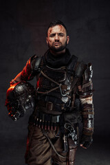 Fototapeta na wymiar Apocalyptic survivor posing with helmet in dark background