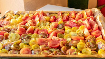 tray with sliced tomatoes, different colors and shapes, autumn harvest